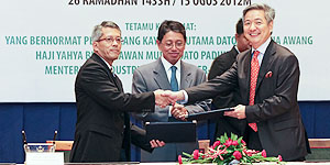 Pehin Dato Awang Haji Yahya witnesses the exchange of documents.