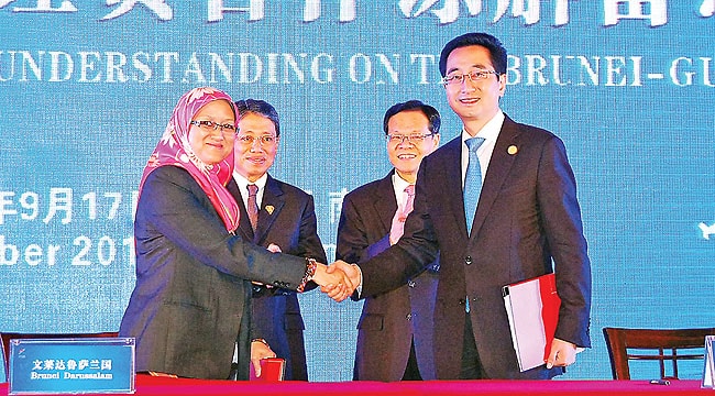 Permanent Secretary at the Ministry of Industry and Primary Resources Hajah Normah Suria Hayati shakes hands with Guangxi Government Vice-Governor Zhang Xiaoqin following the MoU signing, as Minister of Industry and Primary Resources Pehin Orang Kaya Seri Utama Dato Seri Setia Awg Hj Yahya bin Begawan Mudim Dato Paduka Hj Bakar and Guangxi Governor Chen Wu look on.